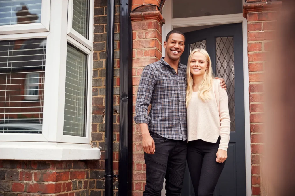 happy-couple-stands-in-front-of-brick-home-2026-03-10-03-19-42-utc
